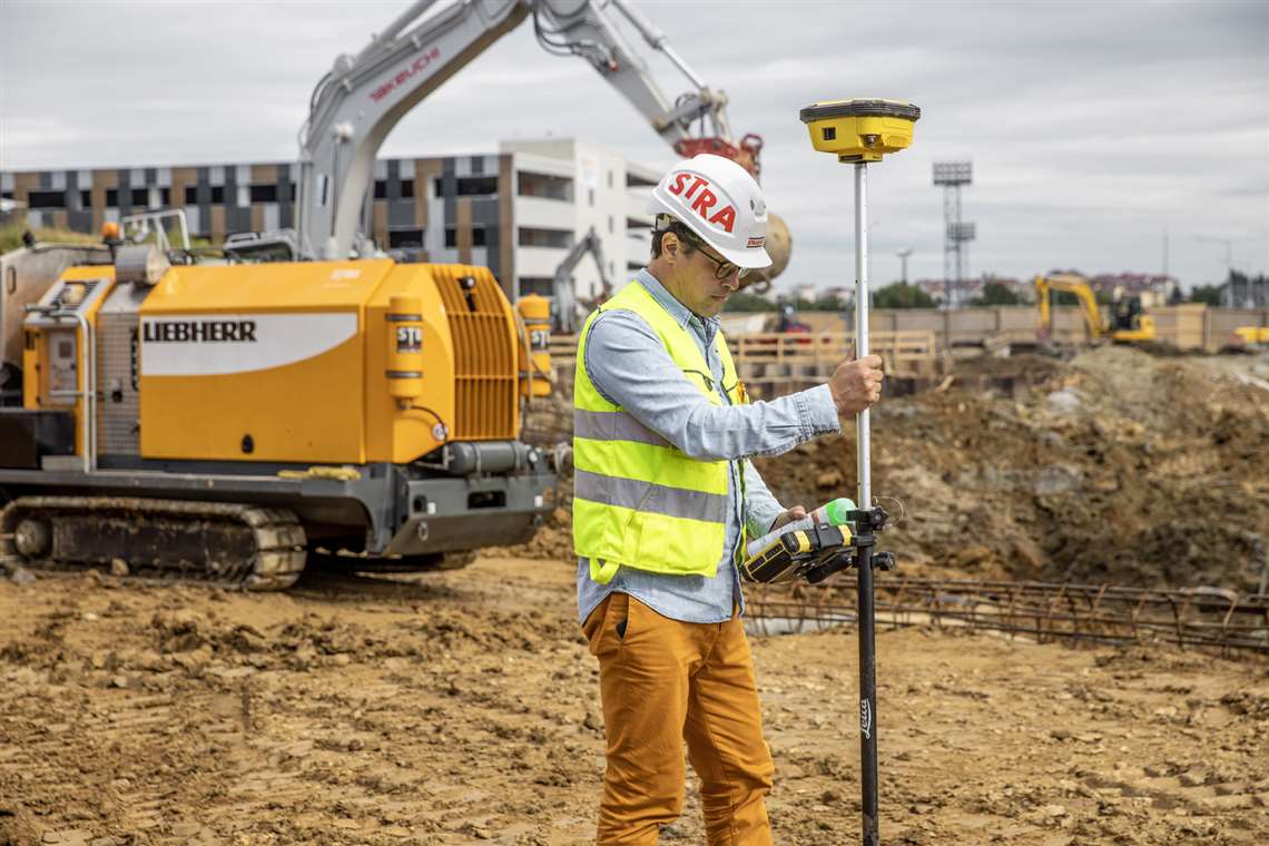 A Züblin worker measures the jobsite to create a digital drilling map for the piles.