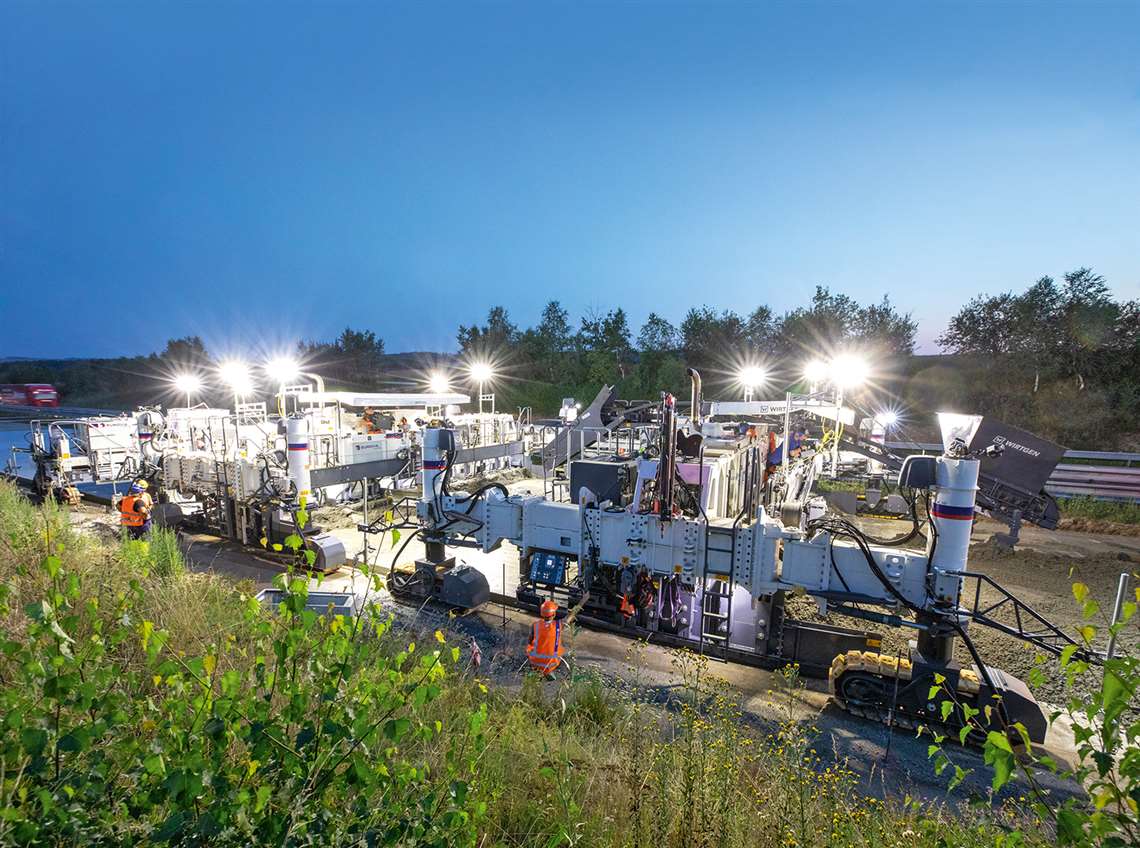 A belt conveyor is used to convey the top layer concrete over and across the first SP 154(i)