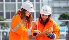 Two female engineers wearing Stantec-branded hard hats