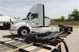 For a pilot project expected to start in 2025, the black coils in the foreground of this photo will be used to transfer power to the heavy-duty electric Cummins truck in the background.