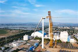 Yellow twin boom crawler crane from XCMG lifting a wind turbine rotor blade