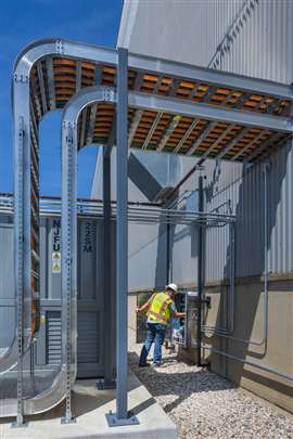 A technician monitors the Battery Energy Storage System (BESS). The facility uses precise control logic to ensure a seamless handoff between stored energy and the plant grid