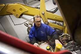 A member of Perkins' CMET team examines a customer's engine