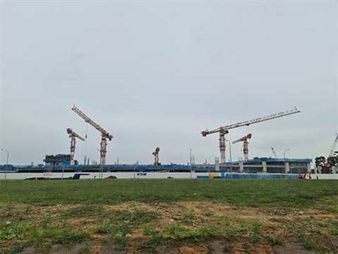 Long range photo of Five Potain MCT 565 flat top tower cranes on the site of the Sengkang West Bus Depot project near Seletar, Singapore