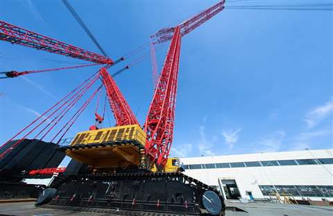 Giant red, yellow and black Sany crawler crane against a blue sky