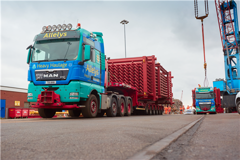 Red oxide colour steel box on a red trailer with Allelys four axle MAN tractor