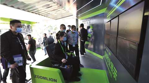 A Zoomlion employee demonstrates its 5G tower crane remote control system.