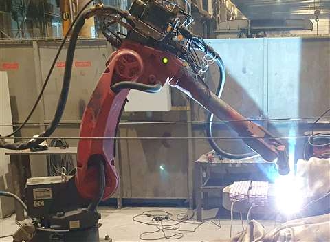 red robot with a welding arc flash at the end of it