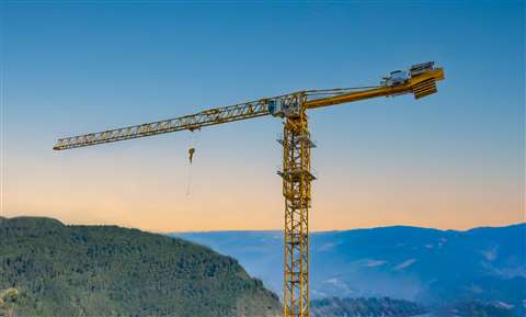 Yellow flat top tower crane against blue sky