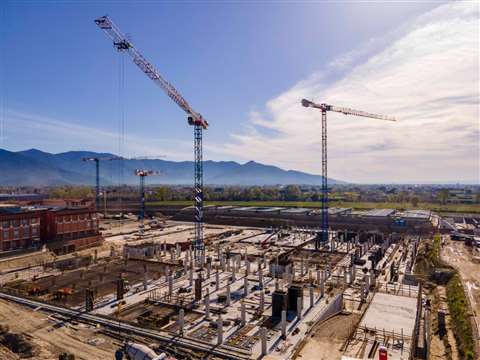 Blue and red and white tower cranes on site