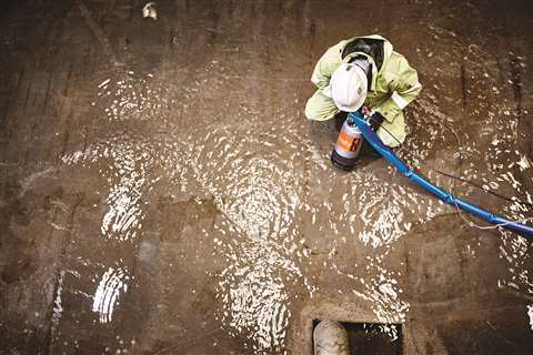 Aeriel show of a worker using a pump on flood water