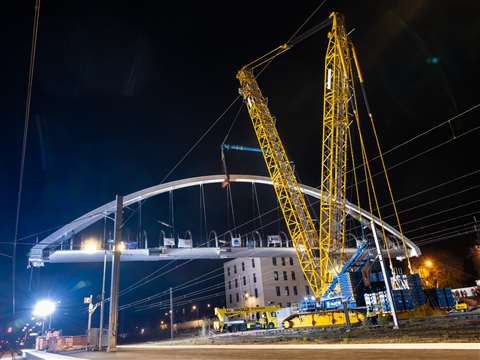 yellow and blue Sarens Tadano crane lifting a bow bridge