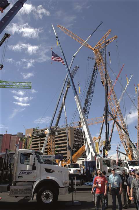 Image of the Conexpo tradeshow with cranes towering above visitors