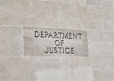 A US Department of Justice sign on the side of a building