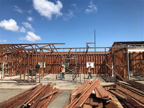 Workers take apart a commercial building in California