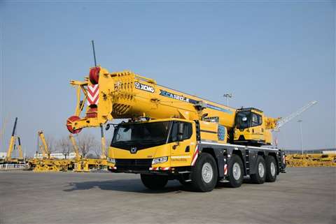 front three quarter view of yellow 4 axle XCMG XCA120 E all terrain crane in transport position