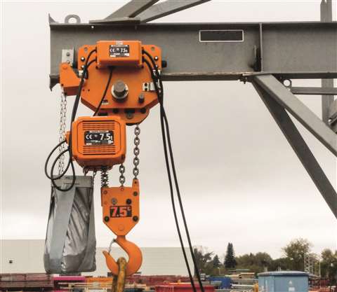 Yellow chain hoist hanging from a beam