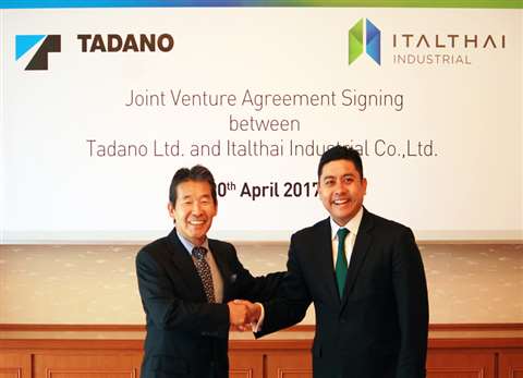 Koichi Tadano, Tadano Group CEO, left, and Yuthachai Charanachitta, Italthai Group CEO, shake hands 