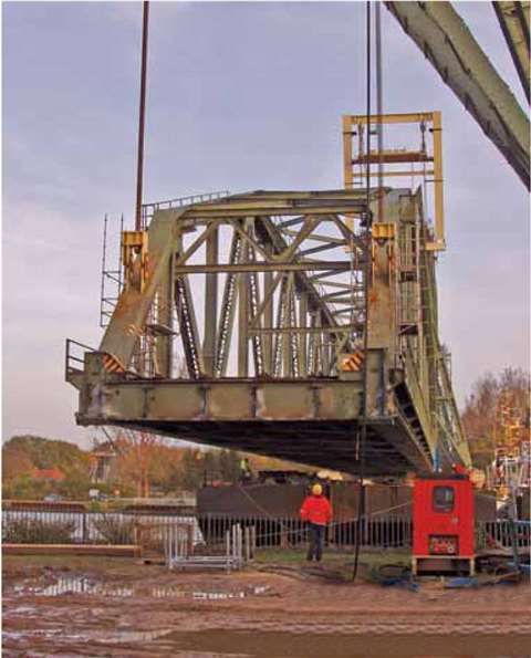 Lowering the old bridge span cate a waiting barge