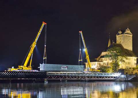 The Liebherr LTM 1160-5.2 mobile crane, shown on the left, installs one of four bridge segments for 