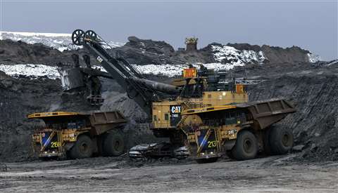 Two Cat 797F autonomous trucks   being loaded in pit