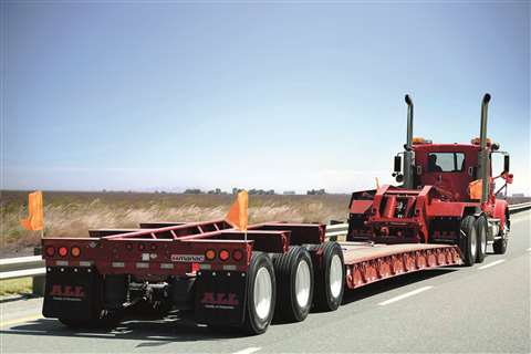 Rear three quarter view of a truck with a flat trailer heading into the future
