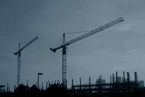 Grey photo of two saddle jib tower cranes