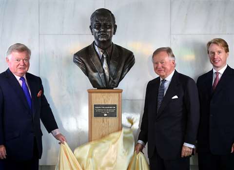 from the left, Mark Bamford, Lord Bamford and Jo Bamford unveil the bust of JCB's founder