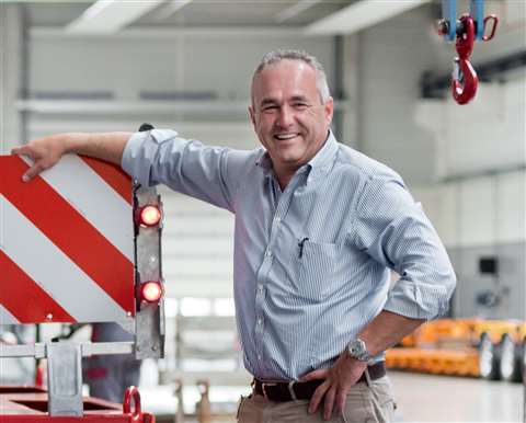 Alain Faymonville in blue shirt leaning on a trailer