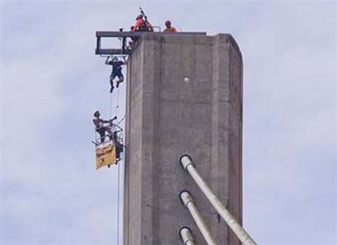 An extreme athlete undertakes the 425-ft pull-up challenge at the top of the Centennial Bridge spann