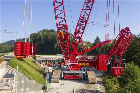 With the central section of the ballast disconnected from the derrick boom the crane positions its suspended ballast