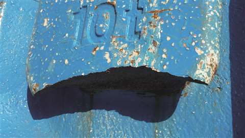 Damaged lifting point on an iron counter weight slab before Rusch repaired it