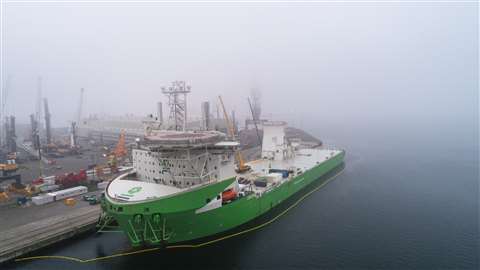 Arrival in the mist of Orion, green hull, white superstructure, at Liebherr in Rostock prior to crane installation