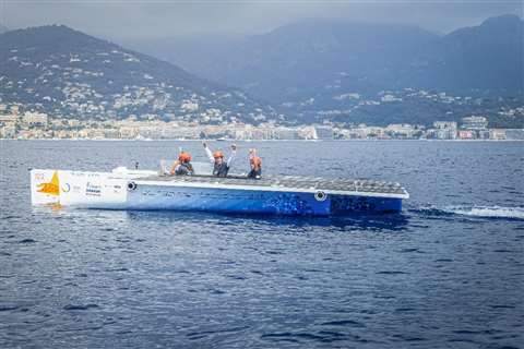 The boat's pilots celebrate as they cross the finish line at the Monaco Solar and Energy Boat Challenge 2019.